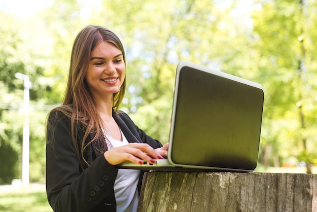 Business woman with laptop in park