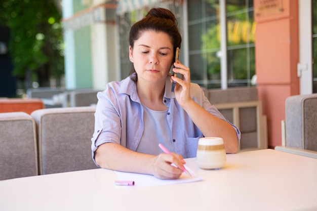 Business woman with smartphone and coffee cupsigned document outside