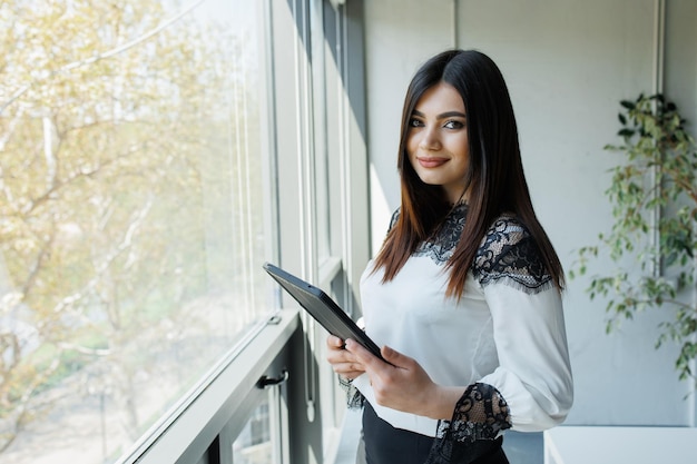 Business woman with a tablet working from an office Young handsome woman administrating a business