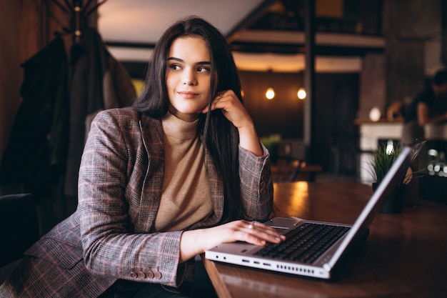 Business woman working on laptop in a cafe