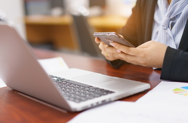 Business woman working at office with laptop and documents on her desk