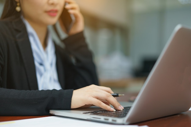 Business woman working at office with laptop and documents on her desk