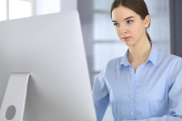 Business woman working with computer at the glass desk in modern office Student girl preparing presentation or bookkeeper making balance Tax and audit concept