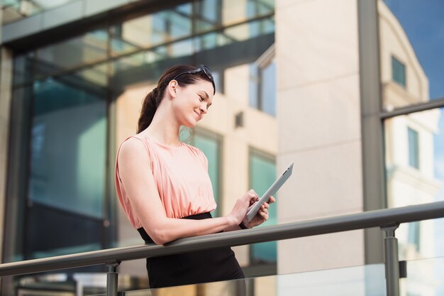 Business woman working with the tablet outdoors near the office