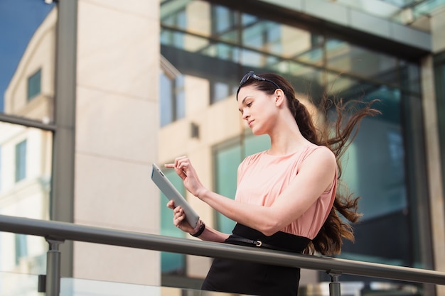 Business woman working with the tablet outdoors near the office