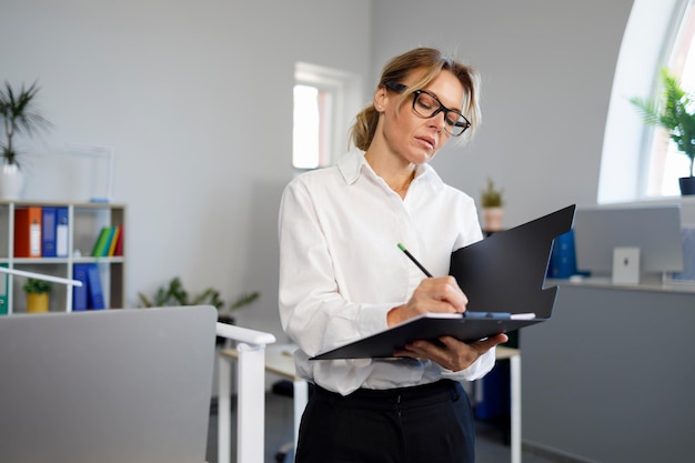 Business woman writing on clipboard