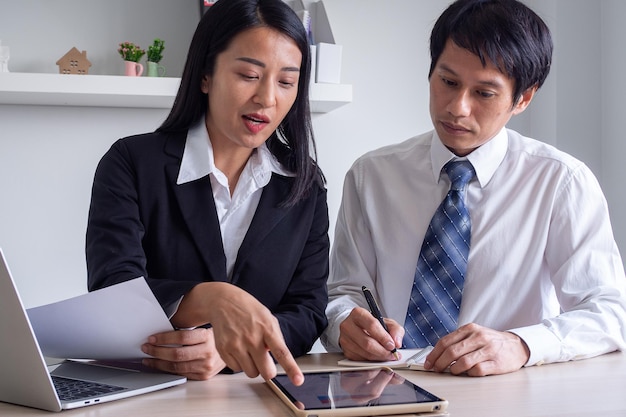 Business women are introducing or consulting businesses to male employees with mobile tablets learning charts statistics and procedures to work in the company