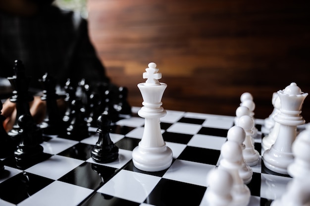 Business women play chess on board  challenges planning business strategy to success concept