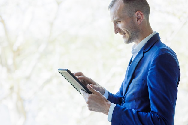 Businessman administrating a business from a digital tablet Handsome entrepreneur doing business