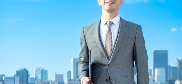 A businessman against the backdrop of the blue sky and buildings