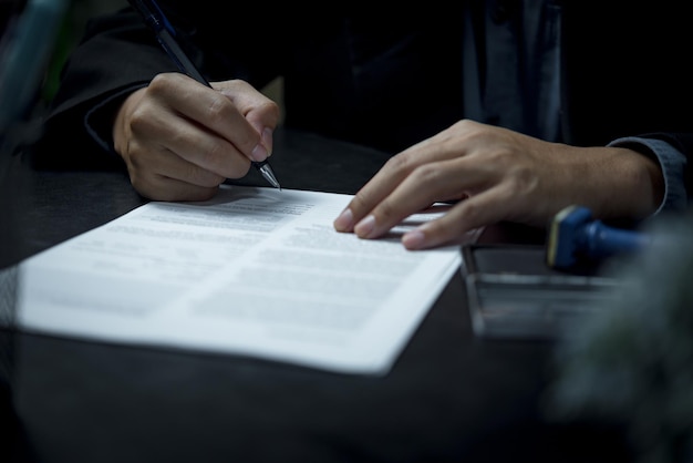 businessman agree to make deal signing document sale contract or legal transaction contract at desk