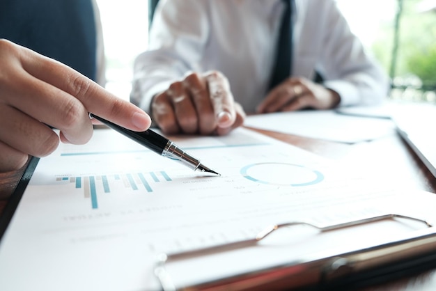 Businessman analyzing investment charts and pressing calculator buttons over documents Accounting Concept