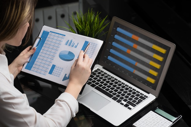 Businessman analyzing investment charts with laptop. Accounting