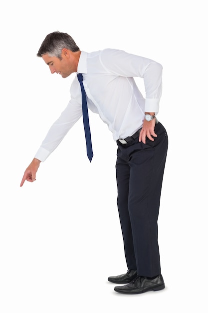 Businessman bending and pointing something down