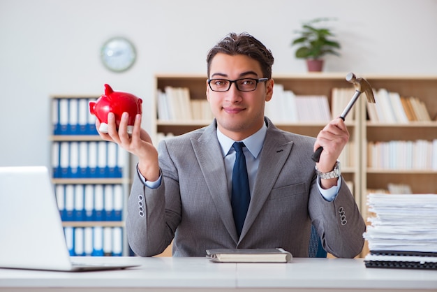 Businessman breaking piggybank in the office