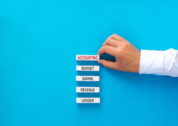 Businessman building wooden bloks with text.