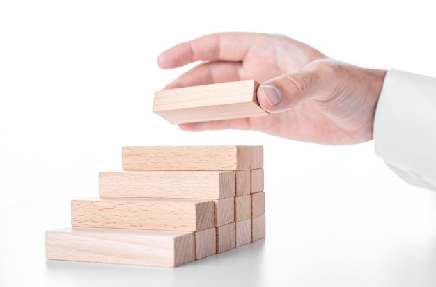 Businessman builds a ladder from wooden blocks