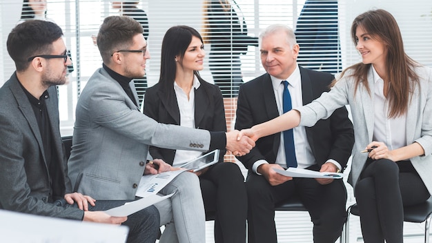 Businessman and businesswoman shaking hands in a conference room. business concept