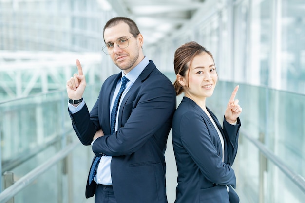 Businessman and businesswoman standing back to back in the building