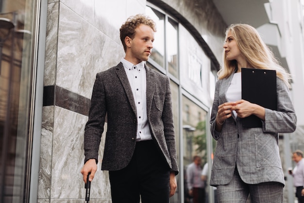 A businessman and a businesswoman walking and discussing work