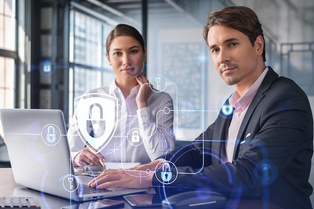 Businessman and businesswoman working together to protect clients confidential information and cyber security IT hologram padlock icons over office background with panoramic windows