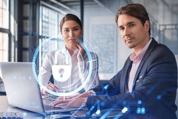 Businessman and businesswoman working together to protect clients confidential information and cyber security IT hologram padlock icons over office background with panoramic windows