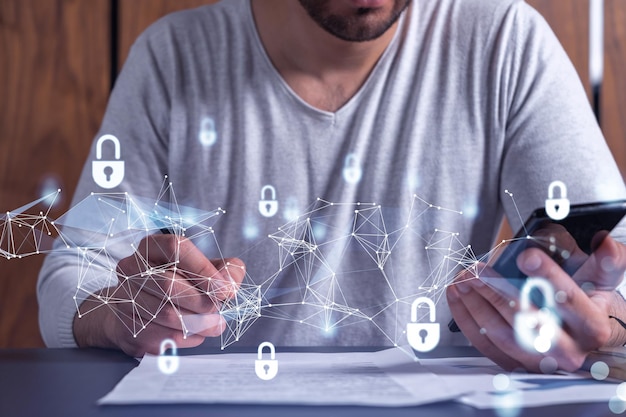 A businessman in casual wear signing the contract to prevent probability of risks in cyber security Checking the phone Padlock Hologram icons over the working desk