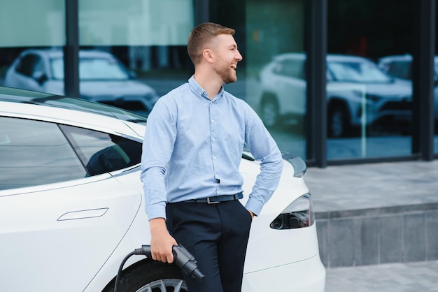 A businessman charges an electric car