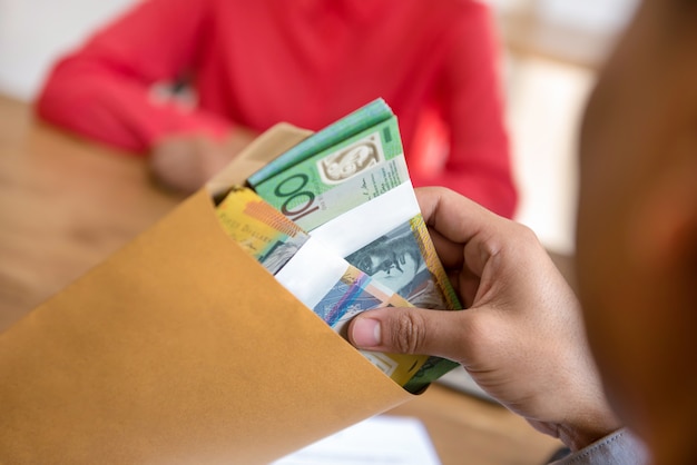 Businessman checking money, Australian dollars, in the envelope