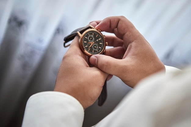 Businessman checking time on his wrist watch