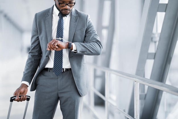 Businessman Checking Time On Watch Walking In Airport