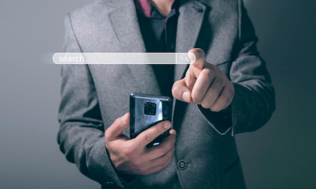 businessman clicks on search while holding the phone in his hands. virtual window