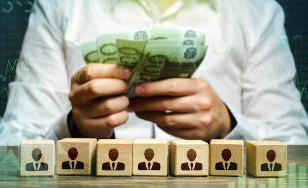 Businessman counting euro money over employee figures Calculation of the companys profit