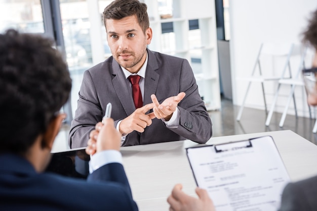 Businessman counting on fingers during job interview, business concept