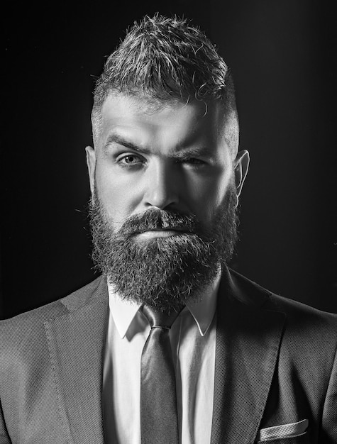 Businessman in dark grey suit on black background isolated Man in classic suit shirt and tie