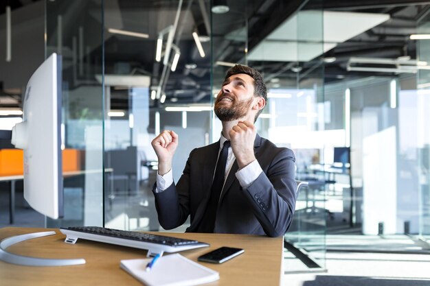 Businessman in despair asks for help raising his hands up asks God for success man works in the office at the computer