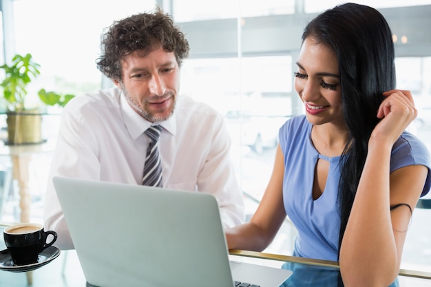 Businessman discussing with colleague over laptop