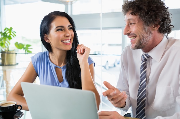 Businessman discussing with colleague using laptop