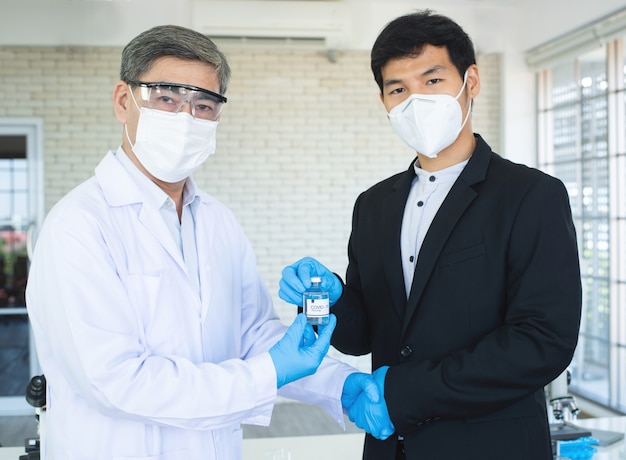 Businessman and doctor shaking hand's for agreement covid19 vaccine in hand.