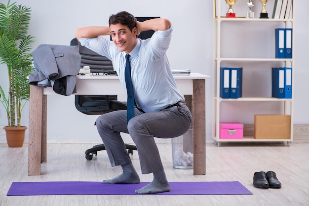 Businessman doing sports in office during break