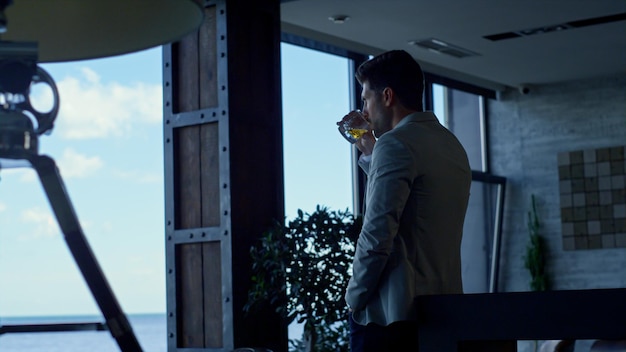 Businessman drinking whiskey in hotel lounge Successful man vacation concept