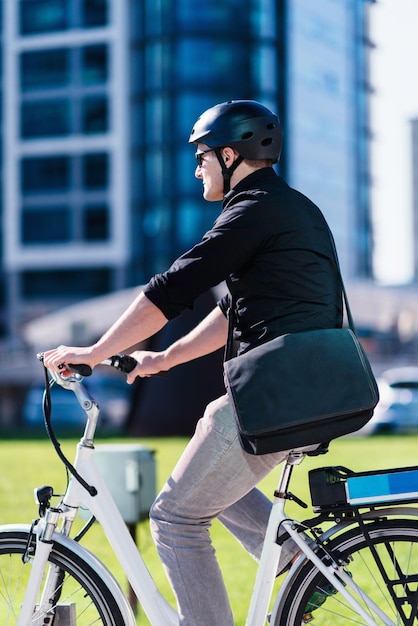 Businessman on electric bicycle in business center