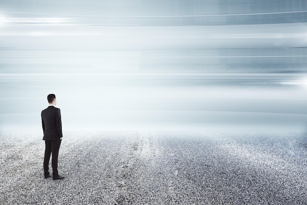 Businessman on empty asphalt road and looking at horizon Find the way concept