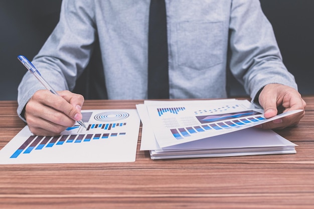 Businessman examining business financial growth graph document