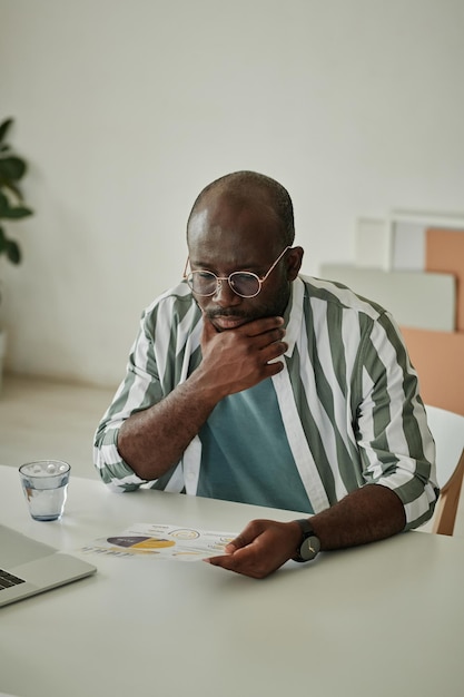 Businessman examining document at table