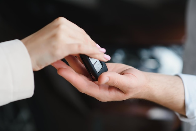 Businessman exchange handing over the car keys for to a young women