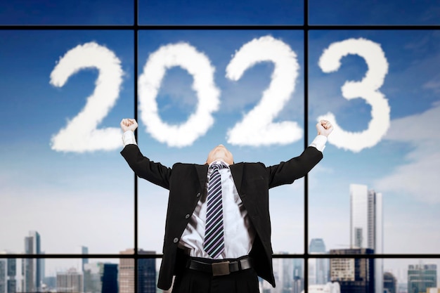 Businessman expressing success near 2023 number