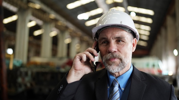 Businessman in factory warehouse is talking on mobilephone Factory indusrty Business