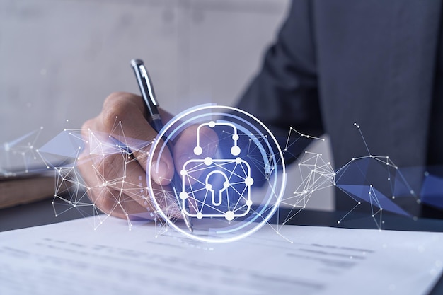 A businessman in formal wear signing the contract to prevent probability of risks in cyber security Padlock Hologram icons over the working desk