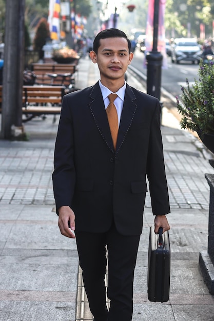 Businessman in formal wear with suitcase walking on the city.